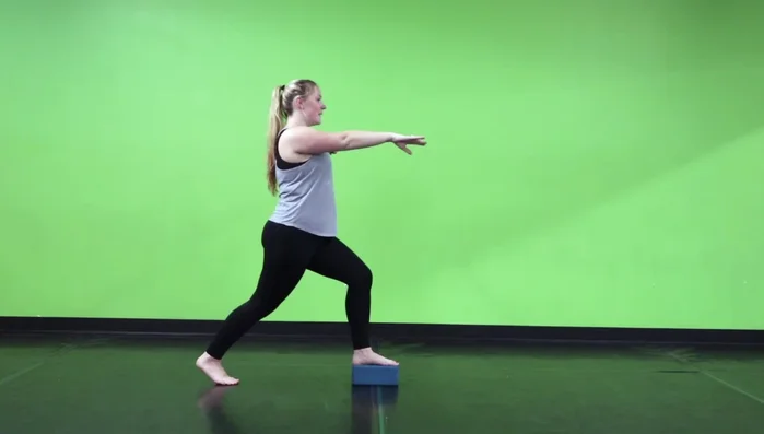 Start in a lunge position with one foot on a yoga block.