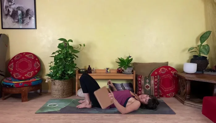 Lie on your back, feet close to your hips. Press your hips up, placing a block underneath your hips at the desired height.