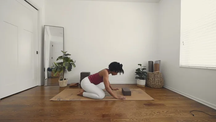 Spread your knees wide and bring your forehead to the block.