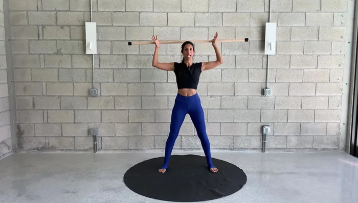 If needed, widen your grip to accommodate tight shoulders. Open your chest while reaching up and down.