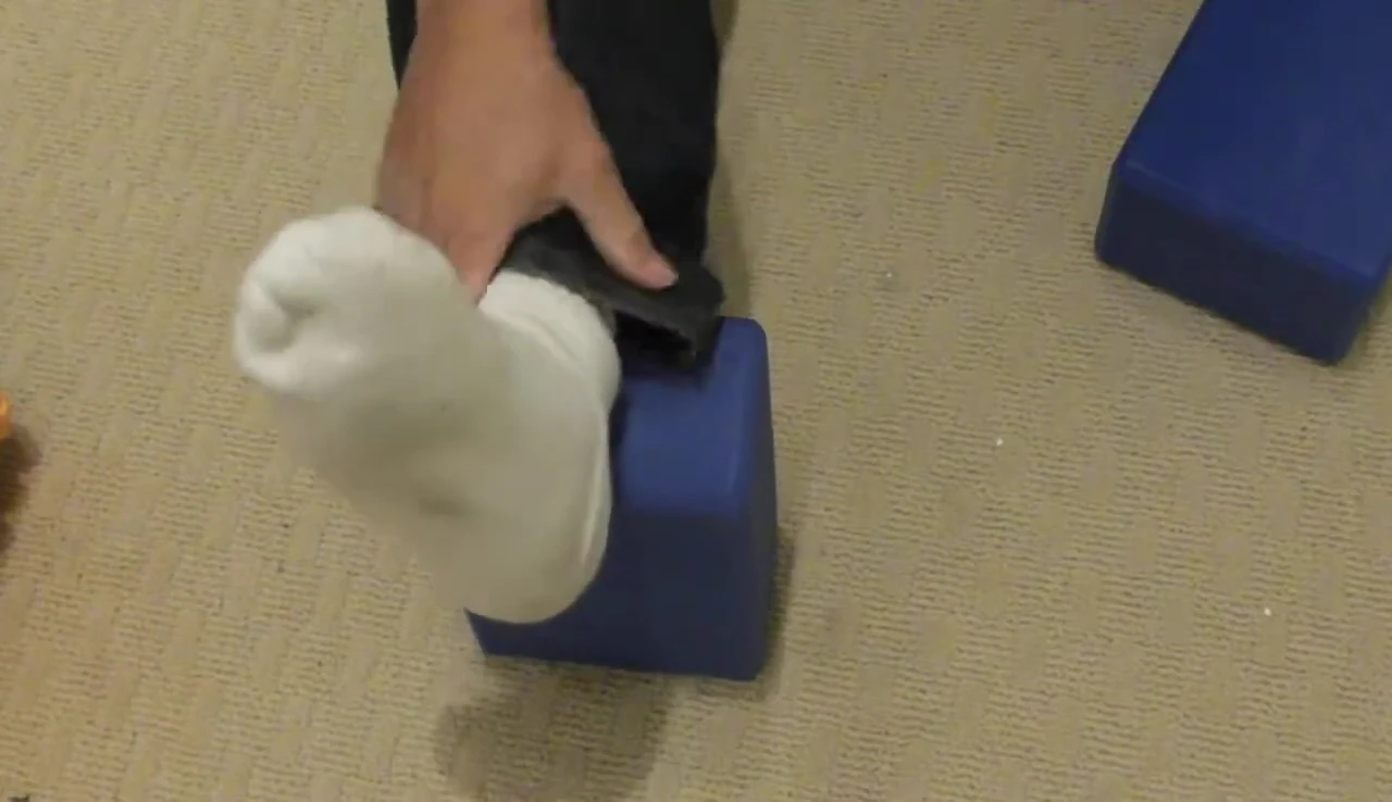 Demonstrating use of the yoga block for support and deeper stretch.