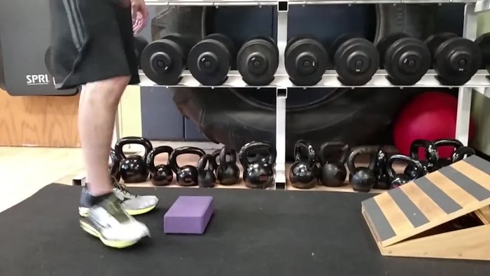 Position yourself with your toes pointing up, heel down, and knee straight.