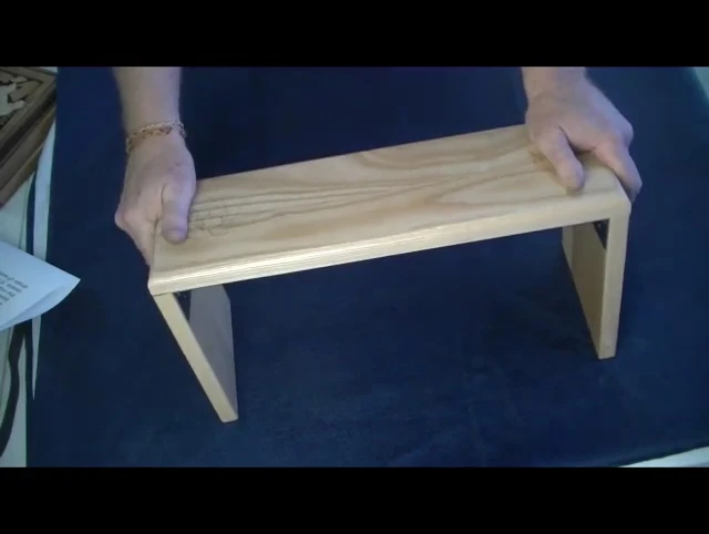 The presenter sits on the bench, demonstrating its comfortable height.