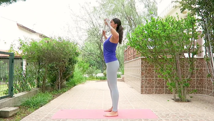 Hold strap in front, elbows bent. Inhale, extend arms upward; exhale, bend elbows. Repeat.