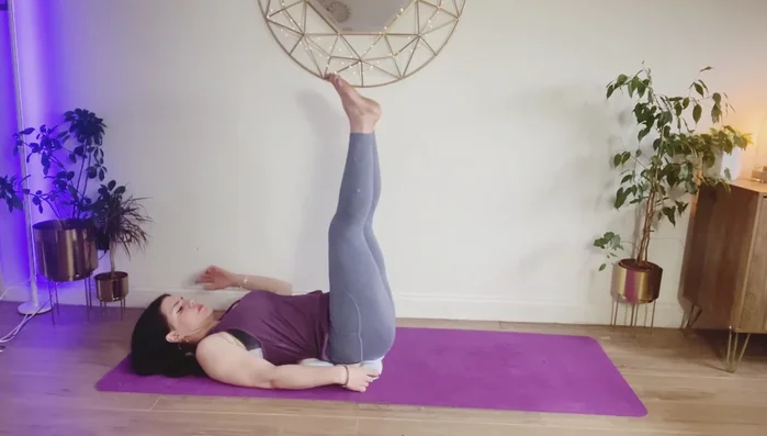 Make the big towel into a square and place at the base of your spine. Lift legs to the ceiling (lower back raised), head supported by the small towel. Gradually bring knees to chest and roll onto your side.