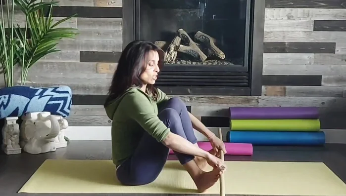 Hamstring, Calf, and Inner Thigh Stretch: Feet on outside of hands, bring feet in and out, engaging core, arms, upper back, and legs for a full-body stretch.