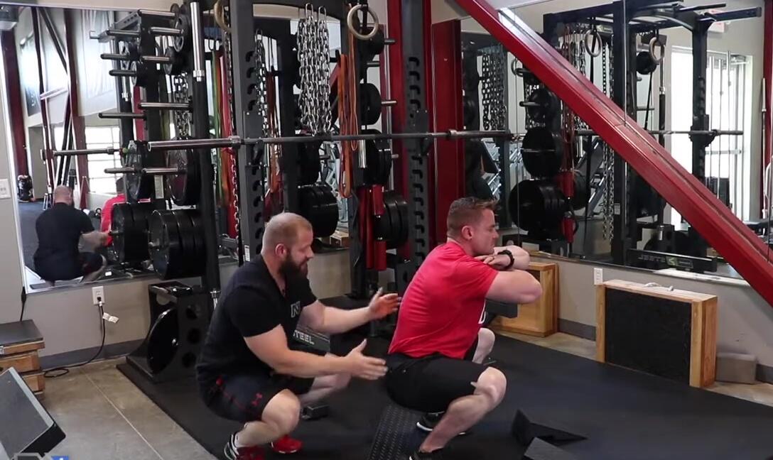 Adam demonstrating a squat with a narrow stance, showing limited range of motion.