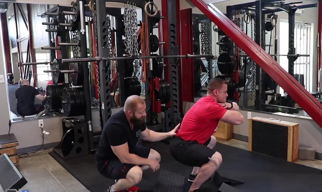 Adam's butt tucking under as he attempts a deeper squat, demonstrating compensatory movement.