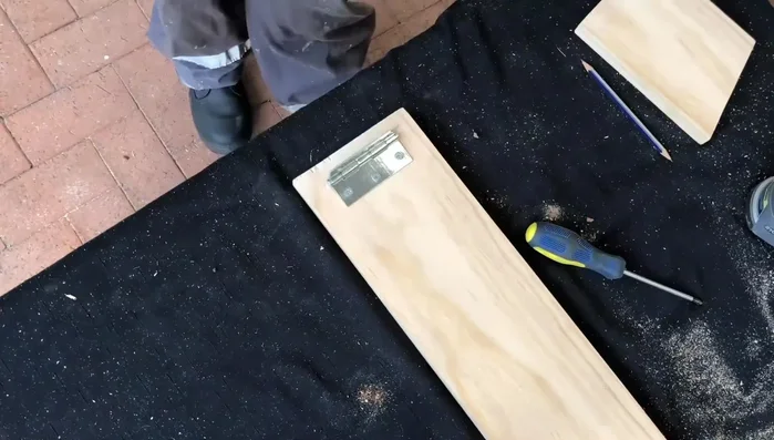 Pre-drill holes for screws to prevent wood splitting. Attach the hinge to the leg using screws.