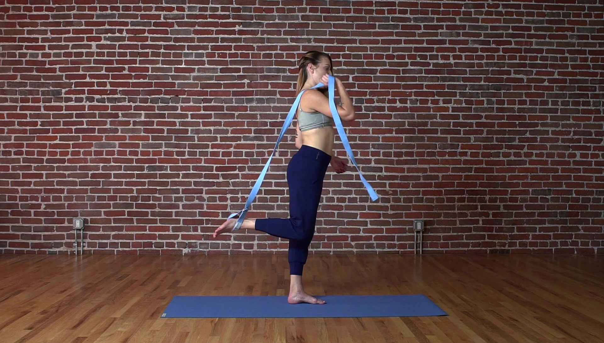 Woman demonstrating the initial balance in Natarajasana prep.