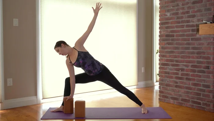 Extended Side Angle Pose (Utthita Parsvakonasana): Bend your front knee and deepen the triangle pose into an extended side angle pose. You can adjust block height as needed.