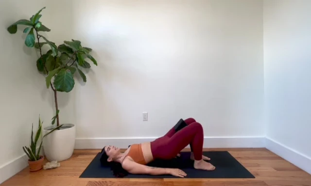 Woman performing tiny pulses at the top of the glute bridge.