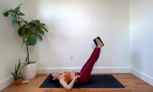 Woman in tabletop position with arms extended, preparing for the advanced core exercise.