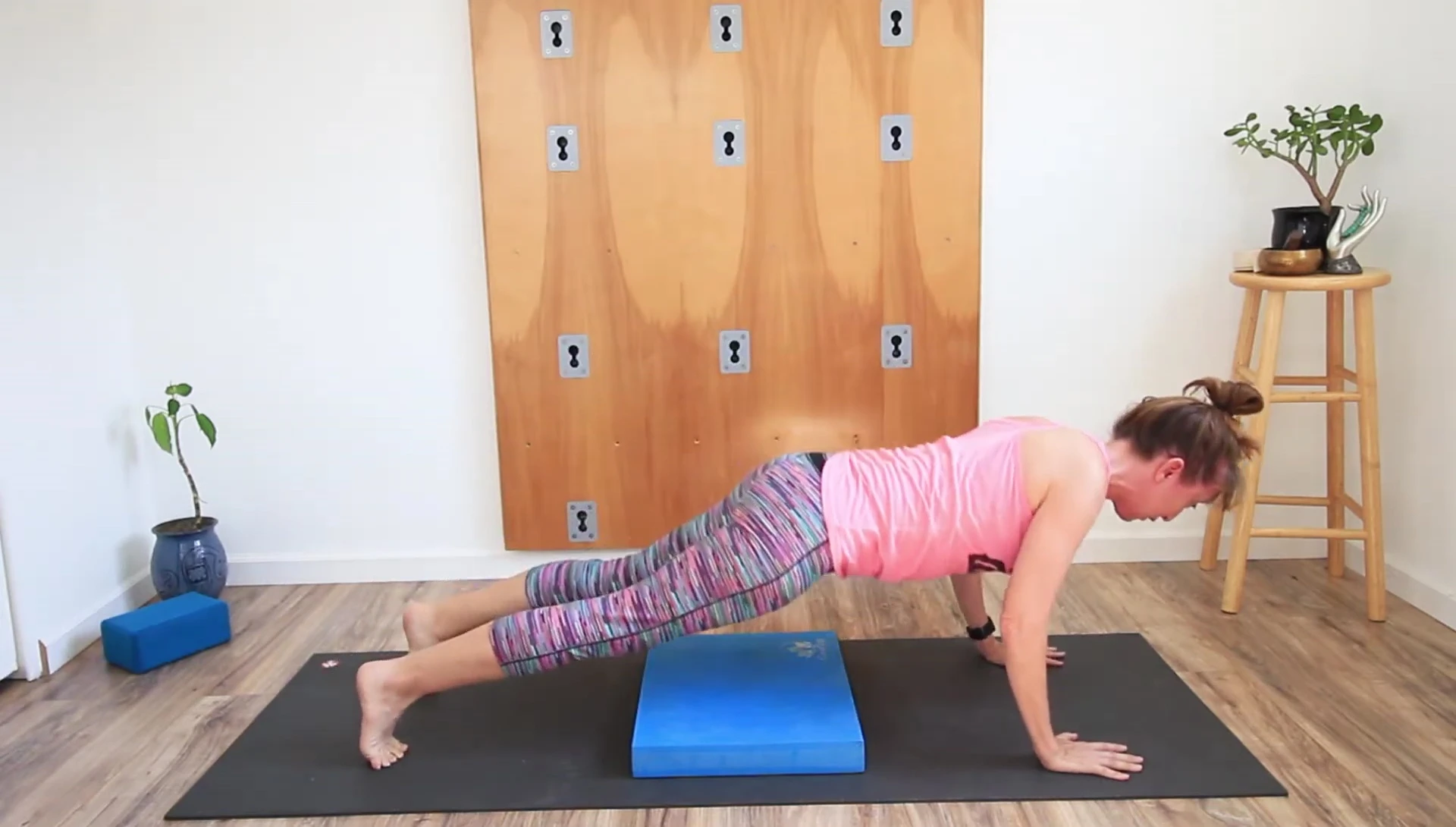 The presenter showcasing the use of the pad for support during chaturanga.