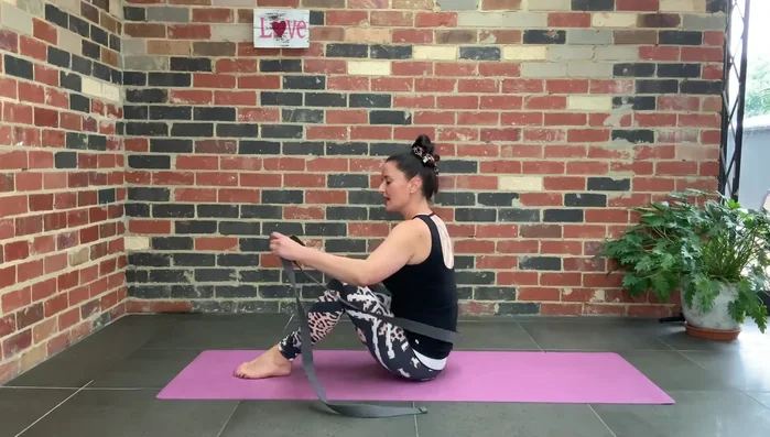 Place the strap under both feet, inside your legs.