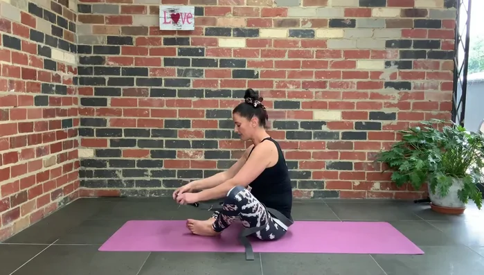 Place the strap under both feet, inside your legs.