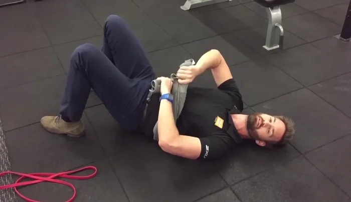 Place the towel across your belly, with your hands on either end.