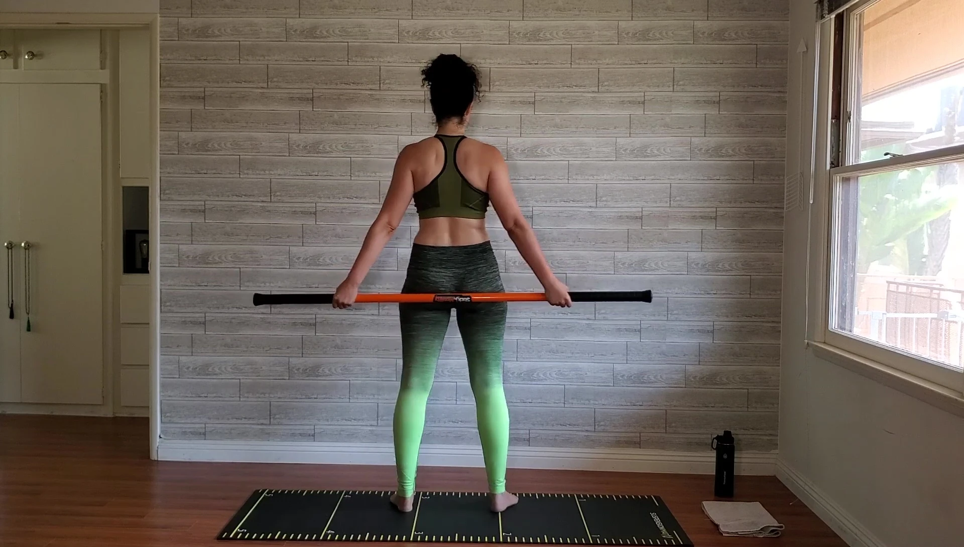 Woman performing the circular arm movements, shown from behind.
