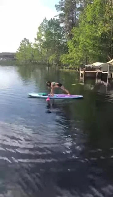 Using the paddle to assist with a warrior one pose in SUP yoga.