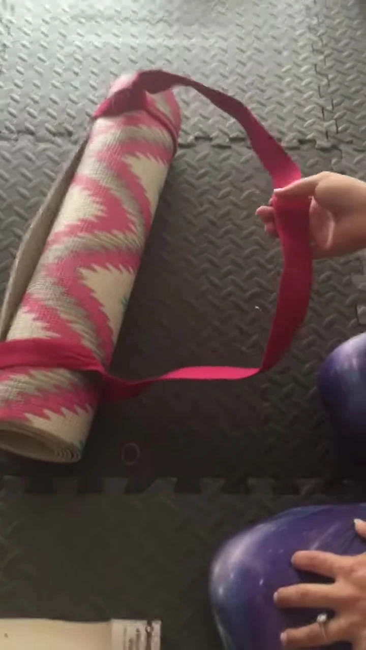 The user demonstrating the use of the strap for stretching poses.
