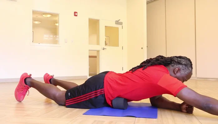 Reach with the arm on the same side as the wedge, then bring it back. Simultaneously, lift and lower the knee on the same side as the wedge.