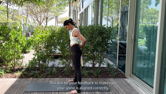 Place the stick along your spine, maintaining three points of contact (back of head, ribs, pelvis).