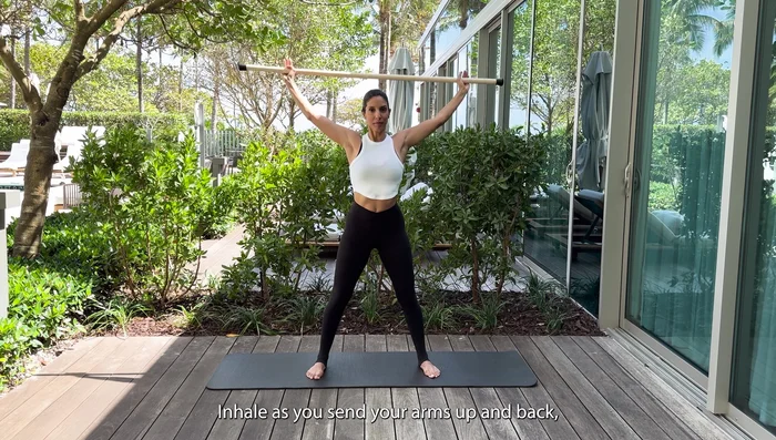 Gradually try to bring the stick further back and down, widening your hands.