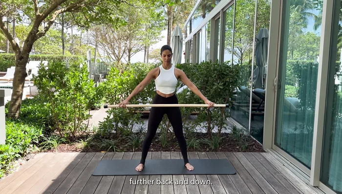 Gradually try to bring the stick further back and down, widening your hands.