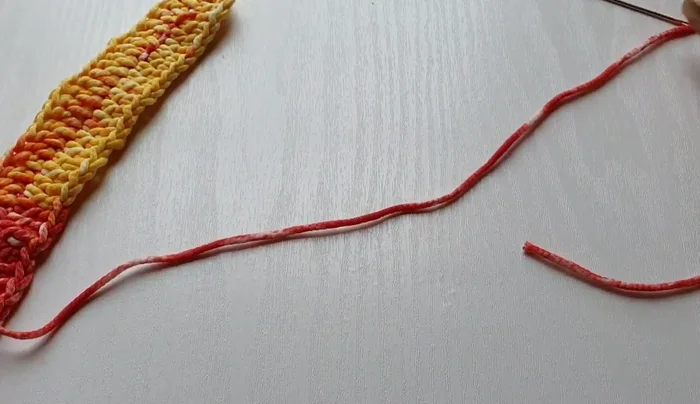 Attach the rings to the strap: Using a smaller hook (or yarn needle), sew the rings onto the strap, ensuring they are centered. Securely fasten off.