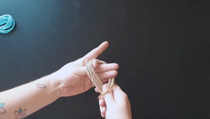 Take a ring and place it on the ropes. Pull the rope through the ring.